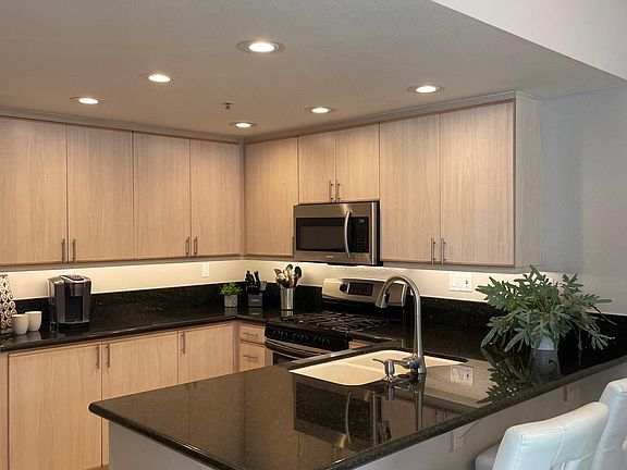 Kitchen has stainless appliances, breakfast bar and plenty of storage.