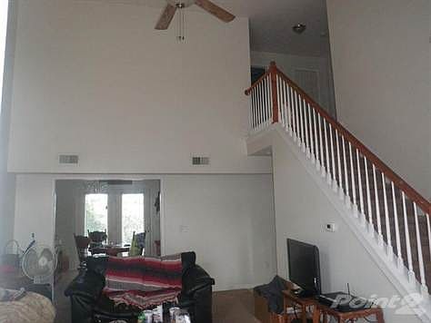 The living/great room has a high ceiling and open stairs to the second floor landing