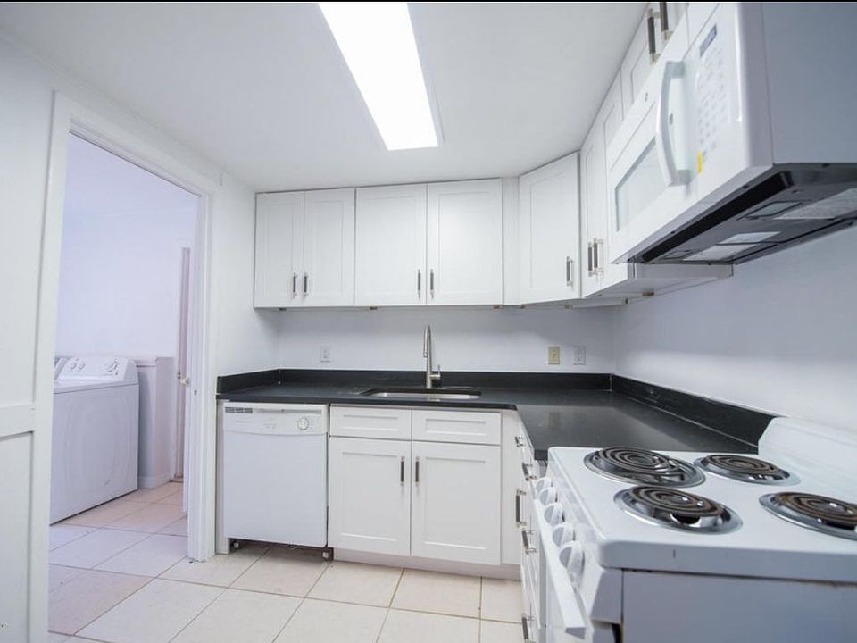 Kitchen with white shaker cabinets, with slow close doors/drawers, and black granite countertops.