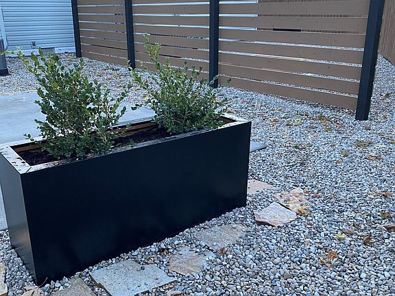 maintenance free landscaping on spacious lot with patios, planter boxes and garden boxes, fenced for privacy
