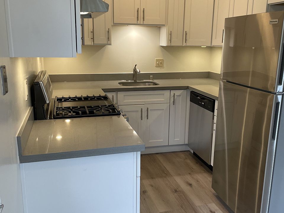 Updated kitchen with quartz countertops, stainless appliances, gas stove, dishwasher, and plenty of cabinet storage.