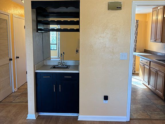 View of wet bar looking into kitchen and hallway