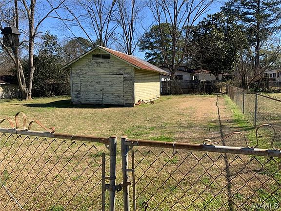 Image 4: Fenced yard with large storage garage or workshop, she/he shed.