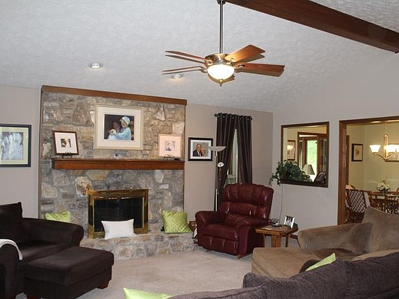 Great room with cathedral ceiling and ceiling fan with light. Open framed window between great room and breakfast area.