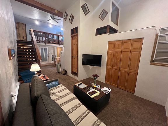 washer dryer behind wooden doors, living room sitting area, TV