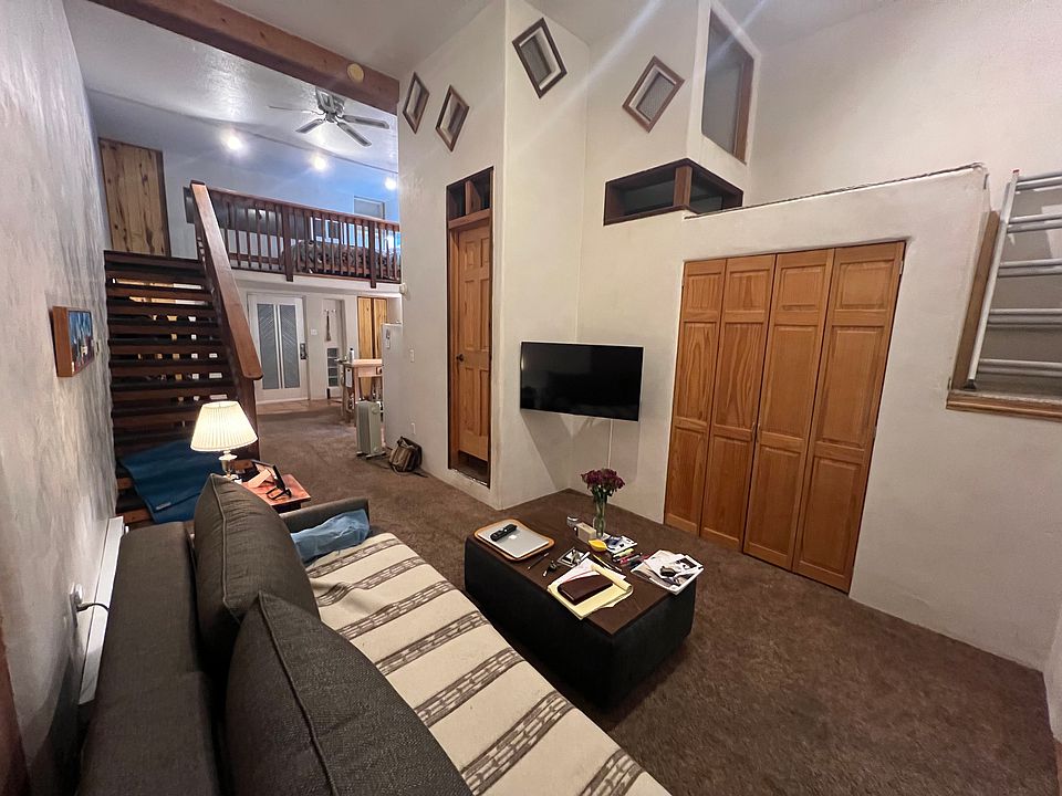 washer dryer behind wooden doors, living room sitting area, TV