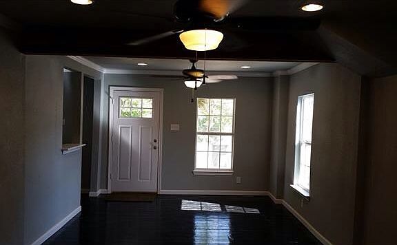 Living space with updated ceiling fan and fixtures throughou