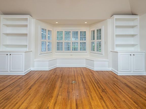 Den with built-in bookshelves and bay window