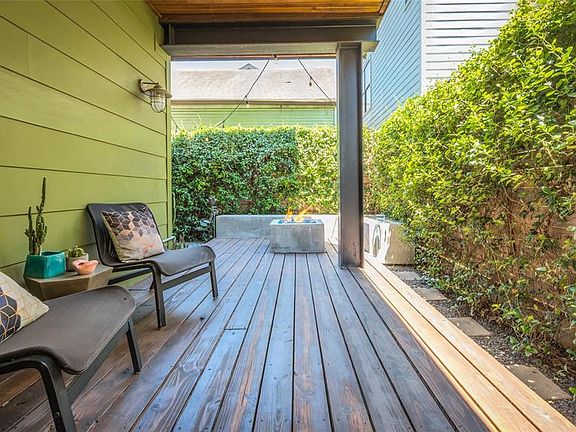 The small backyard space has been transformed into a serene oasis, ideal for entertaining. Step out from home under covered front porch and look out onto custom cement benches in corner with center natural gas fire pit. Imagine the scent of the jasmi