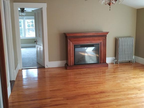Living room with faux fireplace.
Door on left leads to the carpeted bedroom.