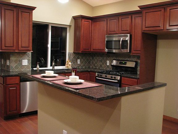 Kitchen w/granite countertops and stainless steel appliances.
