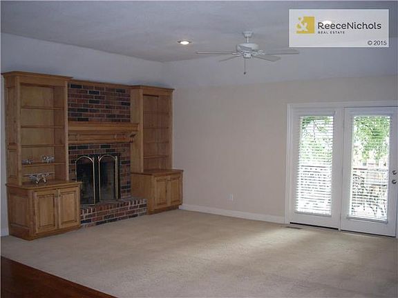 Large Great Room accented with brick fireplace and built-in bookcases, French Doors going out to oversized  deck and backyard