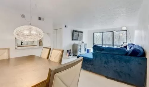 Open living and dining area. Large TV can stay mounted on the wall for use during lease. Tons of natural light with the large sliding glass doors. - 327 Ridge Point Cir #A22