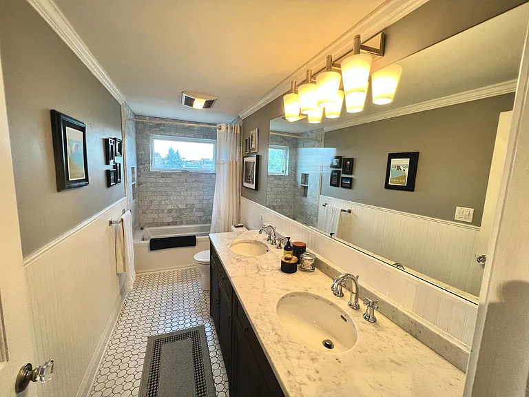 Bathroom upstairs with dual sinks and heated floors. Italian marble shower/tub.