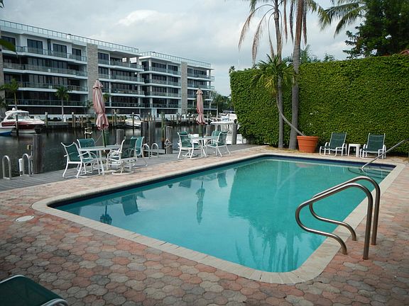 View of Pool, Deck & Dock from Deep End - Chaise Lounges at each end, plus 2 Tables with Umbrellas & 4 chairs each for Dining by the Water.