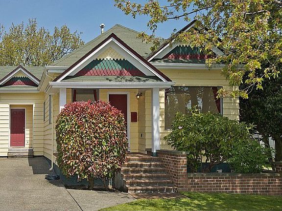 Charming 1900 bungalow with Victorian detailing, cedar siding, brick planters and ample off street parking.