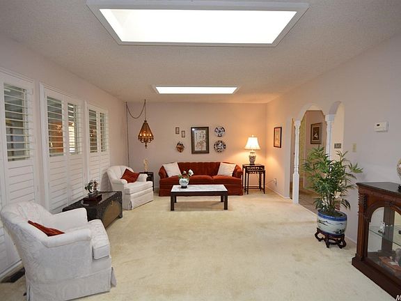 Formal living room with two skylights and large windows overlooking the backyard