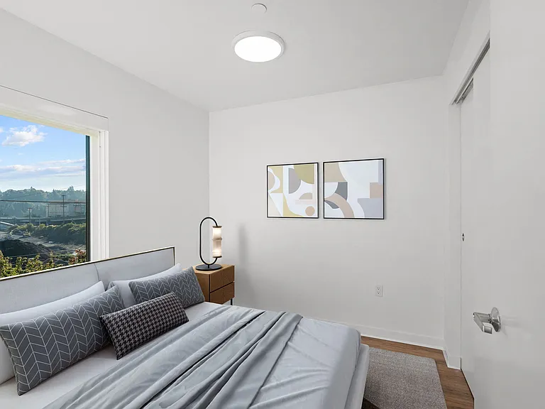 This bedroom features a comfortable bed and a large window, offering a bright and inviting space for relaxation.
