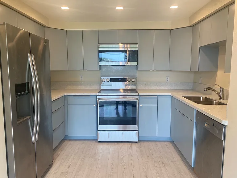 Newly renovated crisp kitchen with quartz countertop, plenty of cabinet space, pull out drawers, new appliances - new dishwasher, garbage disposal, new sink, oven and microwave.