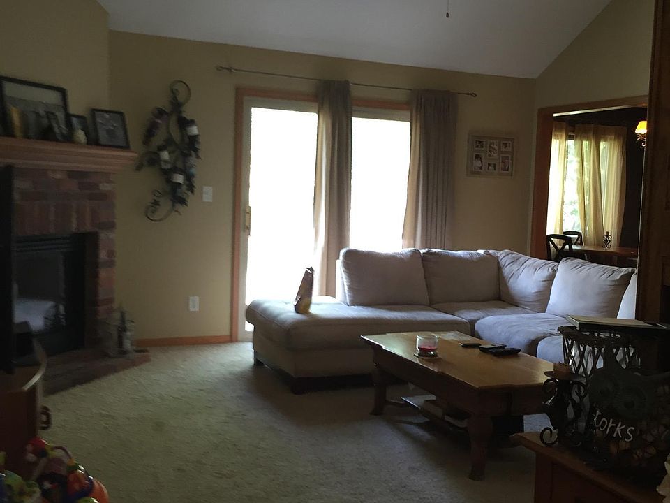 Upstairs Main Living Area looking out from top of entry stairs towards deck and backyard; electric fireplace on left.