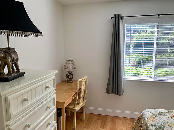 bedroom with east facing bedroom , blackout curtains desk and refrigerator and microwave in the room