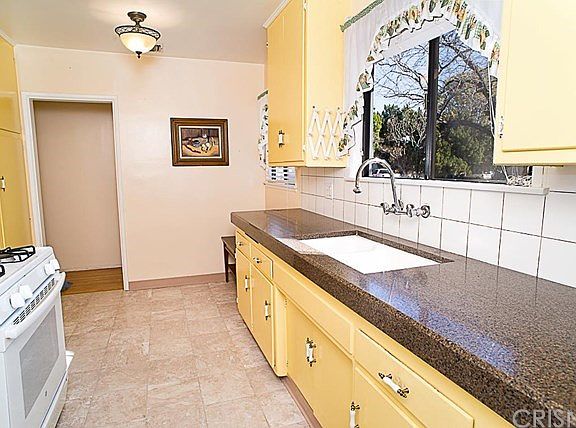 The cooks kitchen with granite counter tops, linoleum flooring, pantry and breakfast nook.