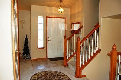Open area with side light at the front door. Short staircase leads upstairs to 3 bedrooms and 2 full