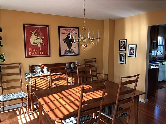 Sunny dining room adjacent to kitchen. Wilsonart laminate flooring continues from kitchen through dining room and into entry are