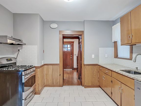 Warm and welcoming, this tile kitchen features a built-in pantry, dishwasher, and modern stove with an attached powder room for everyday ease. It offers the perfect flow for cooking, gatherings and get-togethers.
