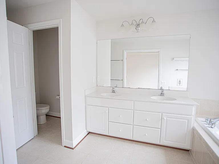Double vanities, lots of storage, oversized mirror, toilet tucked behind a separate door for privacy