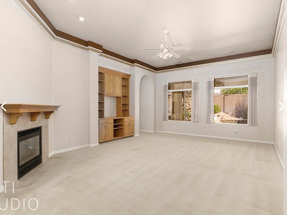 Spacious Living Room with Fireplace, Cabinets, and high Ceiling