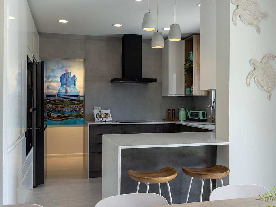 High-end kitchen with bar table, BESPOKE Samsung fridge, GE new appliances, induction stove. Fully equipped with cooking utensils, cookware, dinnerware. View from dining zone.