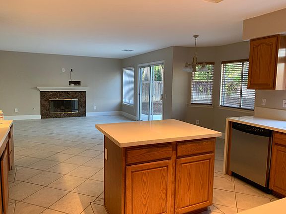 Island can accommodate barstools and is convenient for entertaining ! Breakfast nook overlooks large private backyard. Living room has a wood burning fireplace and a sliding glass doors leading to the backyard.