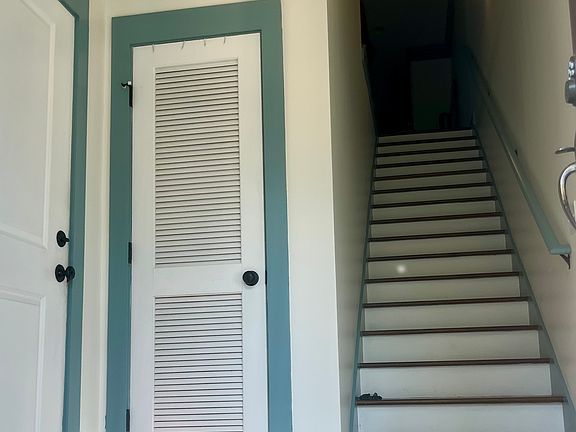Entryway with coat closet, entrance to garage (on left) and staircase to main level.