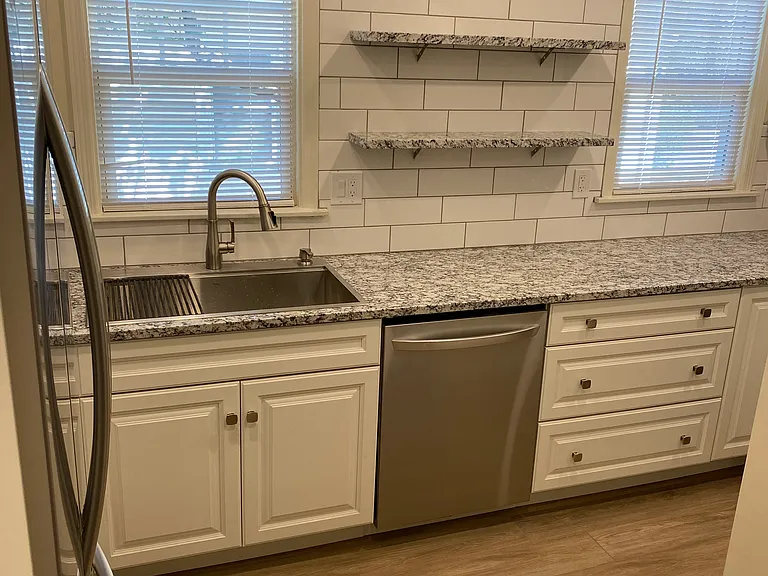 New kitchen remodel with granite countertop and stainless steel appliances.