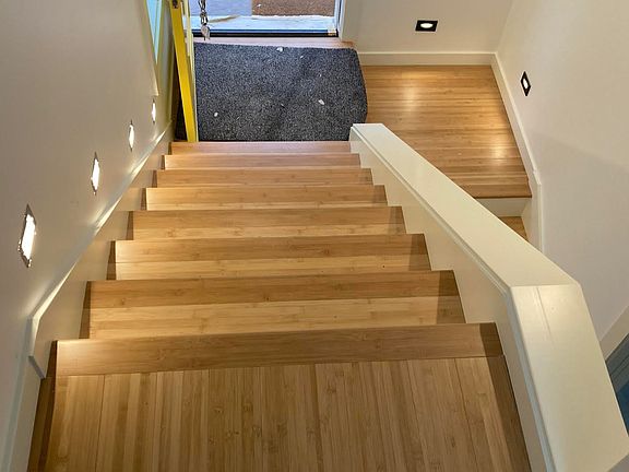 Stairway from living room down to front door. Note landing area leading to 2 bedrooms below.