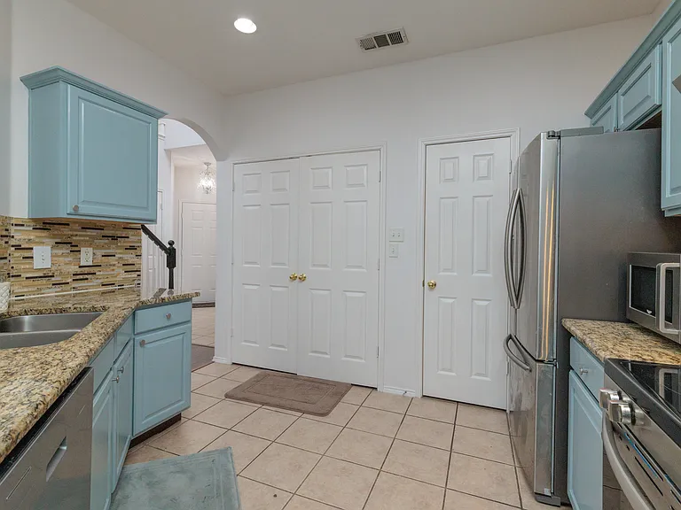 Open kitchen concept with all the major appliances with 2 bar top stools by the pass through. With the washer/dryer in laundry closet.