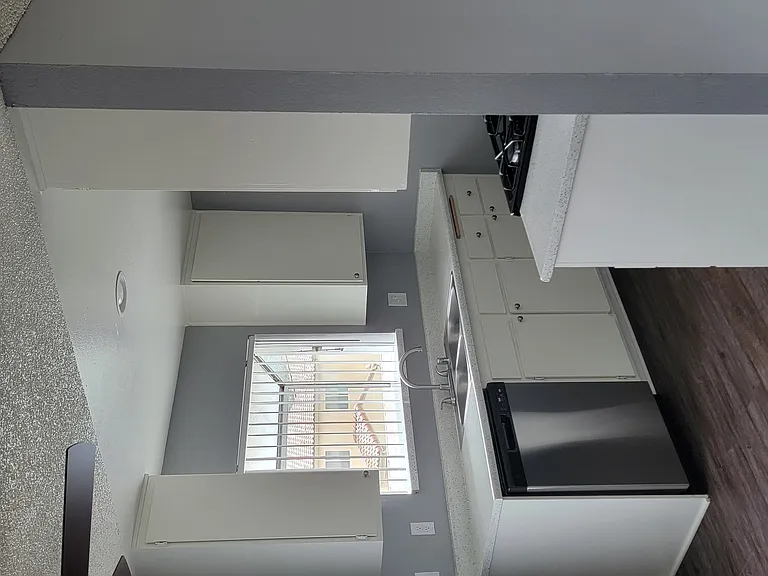 Kitchen and dining area with hardwood style flooring at Grand Oaks Apartments in Lake Elsinore, California.