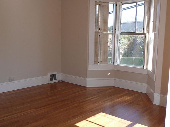 Living room with bay window with greenery across street and open sky view to the south that provides so much sunshine and brightness to your living space. Makes you happy.