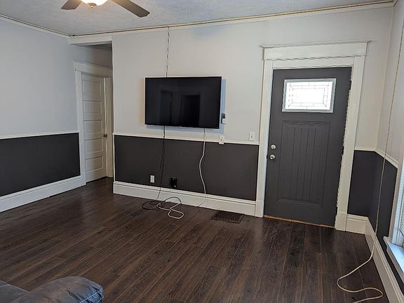 HARDWOOD FLOORING IN COMMON ROOM WITH FURNISHED 55'' SMART TV ON WALL