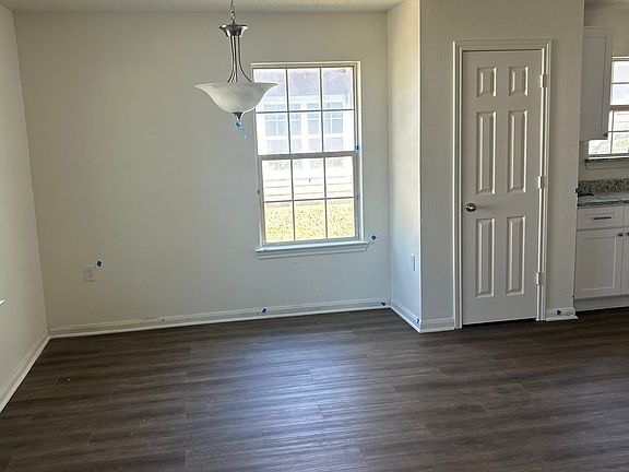 Spacious dining area with modern light fixture.