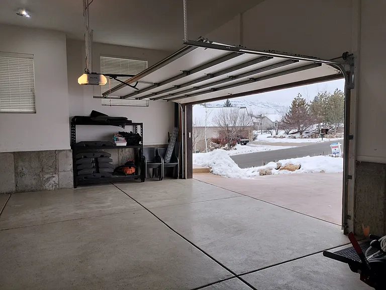 The property includes a two-car garage with extra storage racks, an outdoor freezer, and a 220V plug for convenient electric vehicle charging. Perfect for secure parking and additional storage needs.