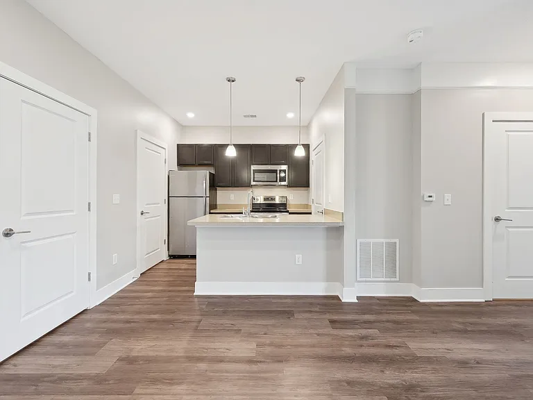 Dooley's Orchard apartment unit showing an updated kitchen with countertops, cabinet, stovetop, oven, and refrigerator.