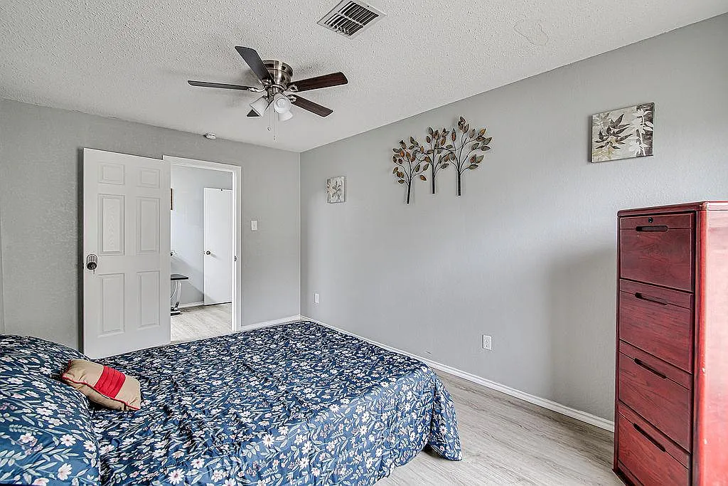 Spacious bedroom with ceiling fan, neutral walls, and room for a full bed plus dresser, with easy access to the hall. - Chapel Glen Ter