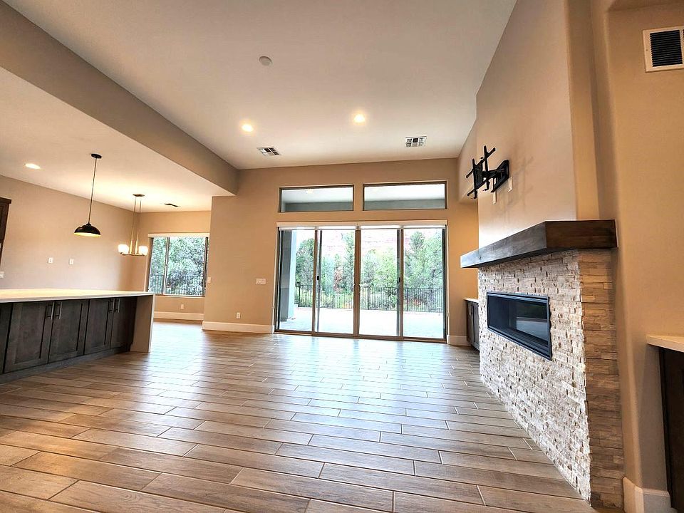Living room has elegant fireplace, oversized windows, and amazing views of Courthouse Rock