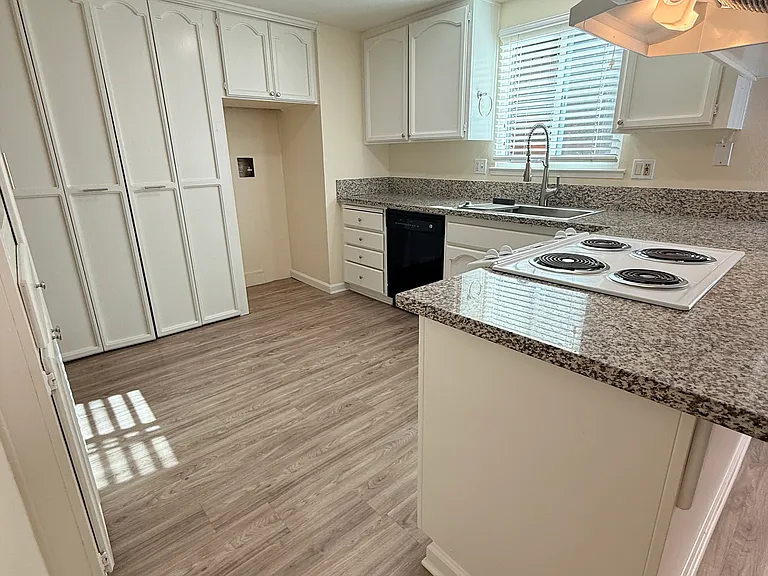 Kitchen with granite counters, laundry closet with hookups