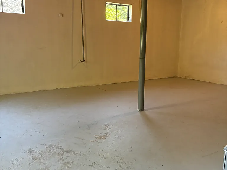 Spacious unfinished basement area with washer/dryer connections, utility access, and flexible storage space.