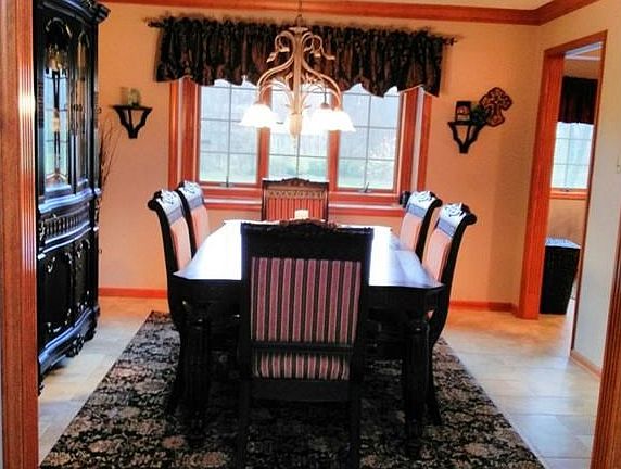 Formal living room leads to the gorgeous formal dining room. Fluted jambs, bay window, ceiling detail, and a stunning view of the full acre yard and mature trees.
