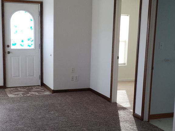 Living room with vaulted ceiling. Showing front door, 1st be