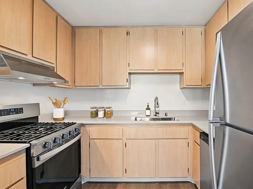 Classic Package II kitchen with stainless steel appliances, oak cabinetry, beige quartz countertops, and hard surface flooring